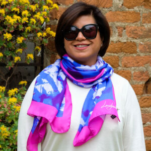 woman wearing cerulean blue and fushcia colour long silk scarf in summer branches design by Louis Jane