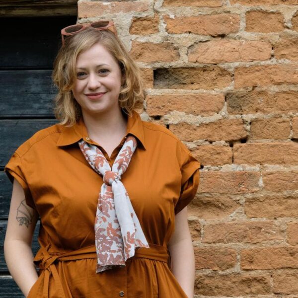 Woman wearing Fern Sprays long silk scarf in Russet and Cool Blue colour under collar of shirt dress