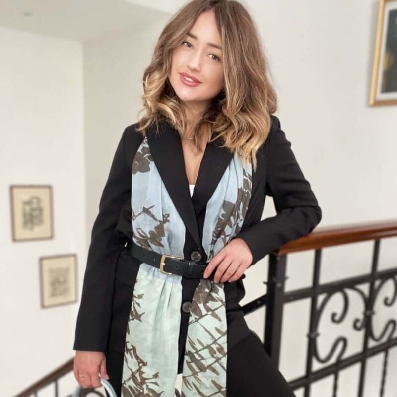 woman wearing Louis Jane Leaves long cashmere and silk scarf, belted, in cobalt blue and seafoam pale green colour